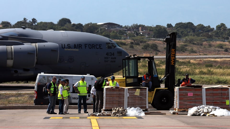 Flugzeug der US-Army mit Kisten im Vordergrund