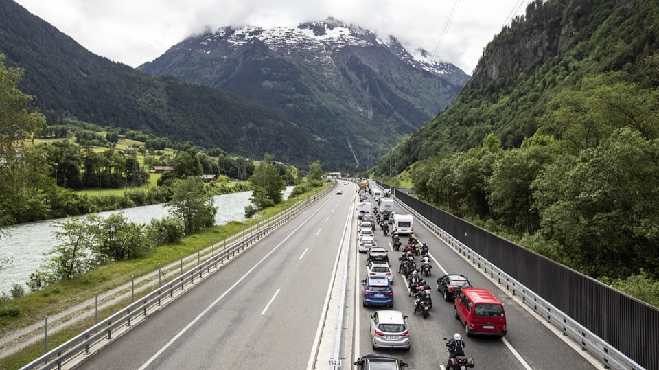 Autos stauen sich auf der Autobahn, im Hintergrund ist das Gotthard-Massiv zu sehen
