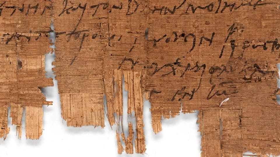 Ein Stück braunes Papyrus, das mit einer schwarzen Schrift beschrieben ist.