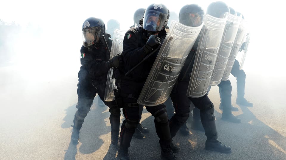 Italienische Gendarmen mit Schutzschild und im schwarzen Gewand.