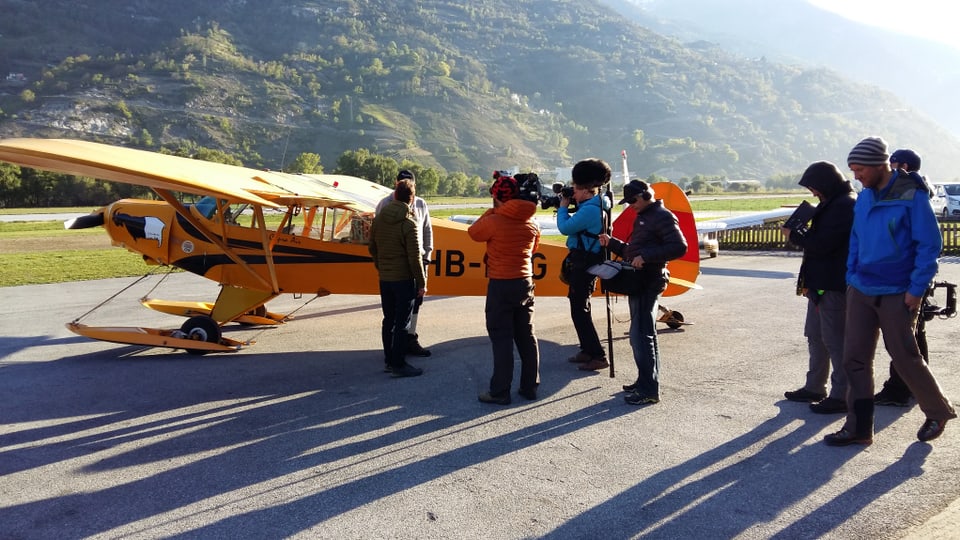 Filmteam steht bei Kleinflugzeug, welches später auf dem Gletscher landen wird. 
