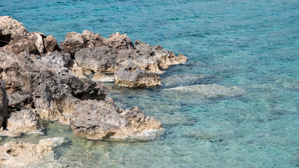 Blick auf Felsen, die aus dem türkisfarbenen Meer ragen