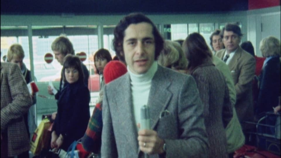 Roger Schawinski am Flughafen Kloten, im Hintergrund Flug-Passagiere.