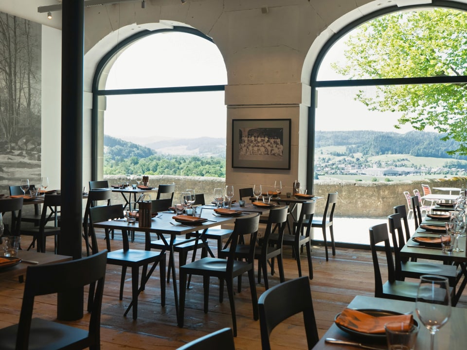 Speisesaal, durch zwei grosse Fenster mit Rundbögen sieht man auf die hügelige Landschaft des Emmentals