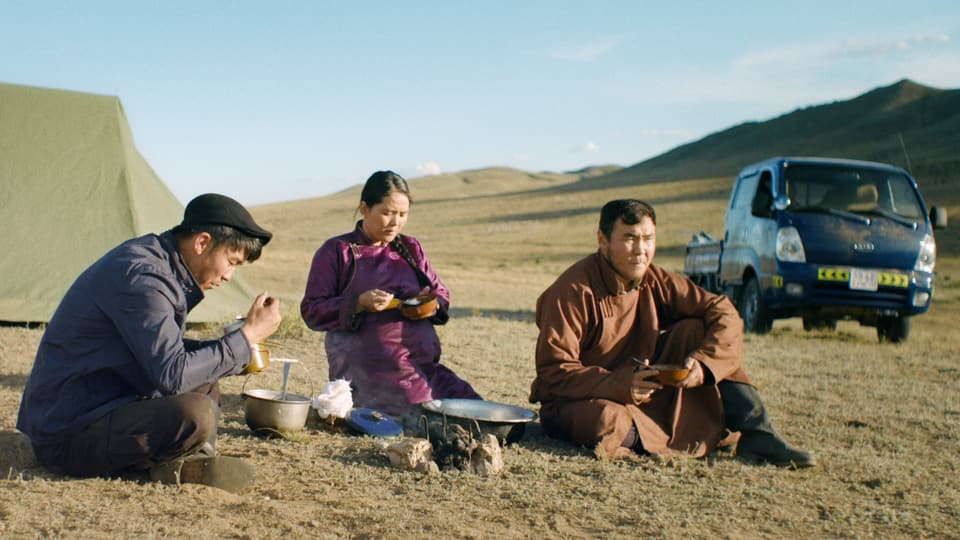 Drei Personen essen in der Steppe