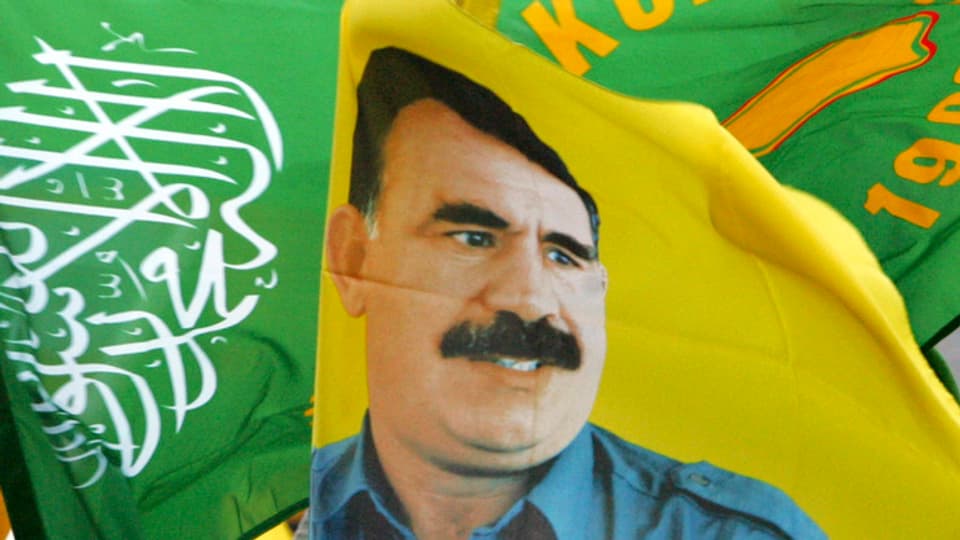 Fahnen mit dem Portrait von Öcalan an einer Demonstration in Deutschland.