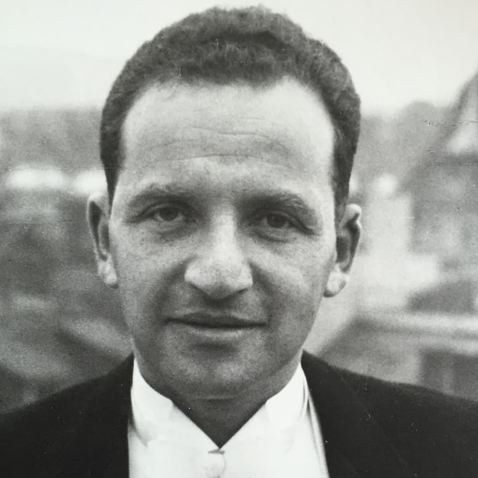 Alte schwarz-weiss-Fotografie: ein Mann mittleren Alters mit dunklen Haaren im Anzug.