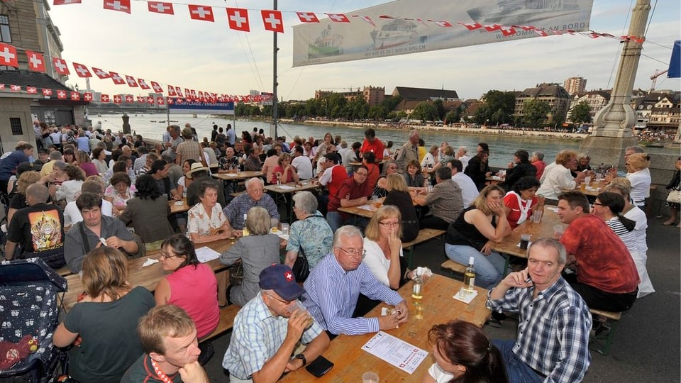 Menschen sitzen an Festbänken
