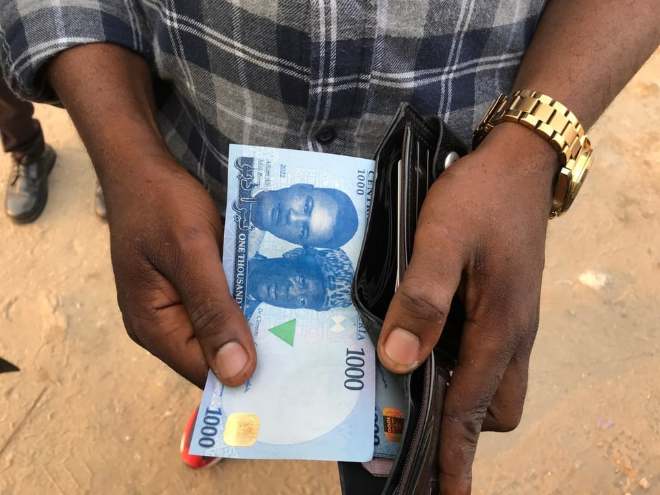 Mann zieht Geldnote aus Portemonnaie (Nahaufnahme)