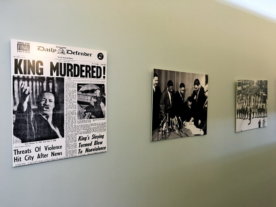 Eine Wand mit Fotos und Zeitungsartikeln.