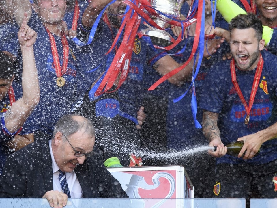 An der Übergabe des Pokals zum Gewinn der Schweizer Meisterschaft 2017 duscht der Spieler des FC Basel Renato Steffen Bundesrat Parmelin mit Champagner.