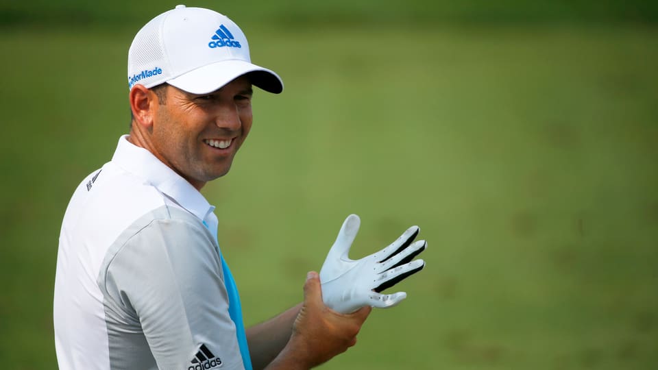 Sergio Garcia zieht sich einen Golfhandschuh an und lacht dabei.