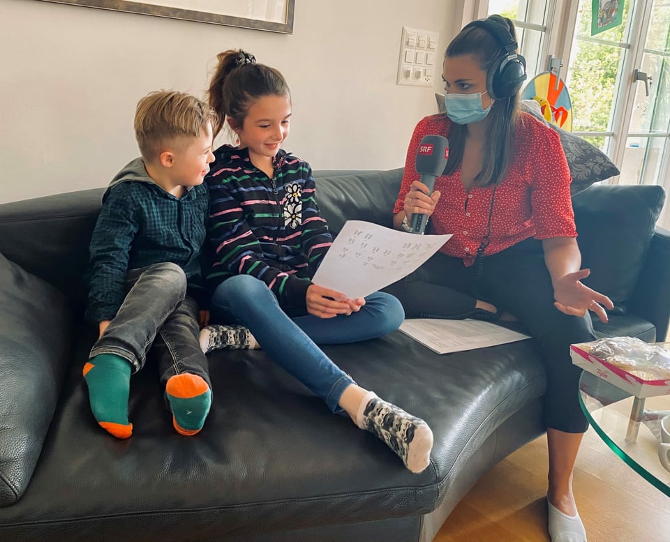 Matteo, Julia und Angela sitzen auf dem Sofa