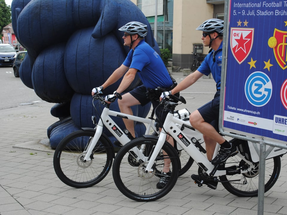 Polizisten posieren auf ihren E-Bikes.