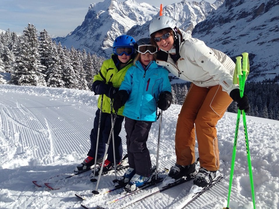 Mutter mit zwei Kindern auf Skiern.