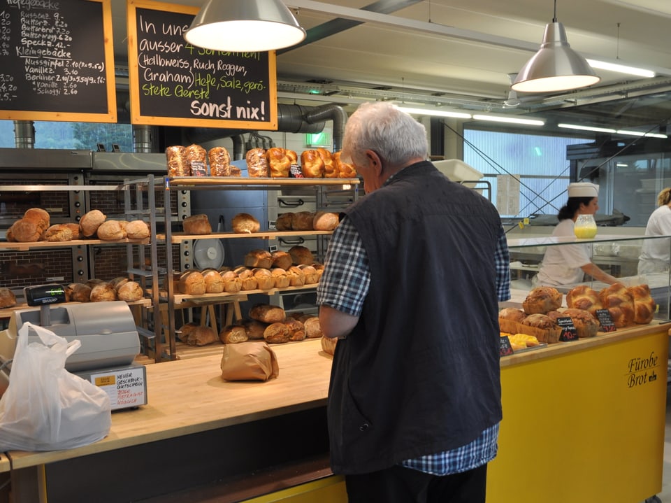 Ein Kunde steht am Tresen einer Bäckerei.