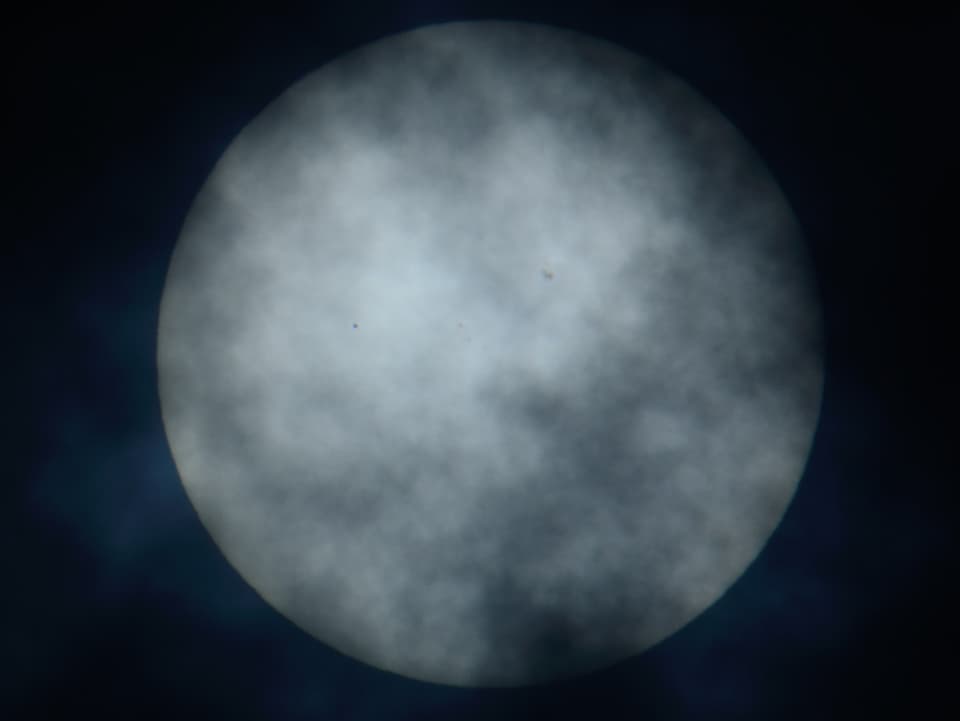 Merkur vor der Sonne und hinter Wolken.
