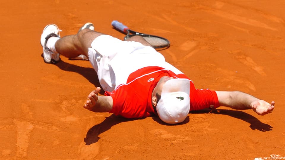 Tennisspieler erschöpft am Boden