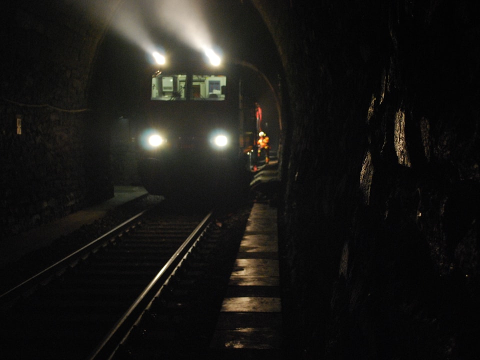 Löschzug der SBB fährt durchs dunkle Tunnel. 