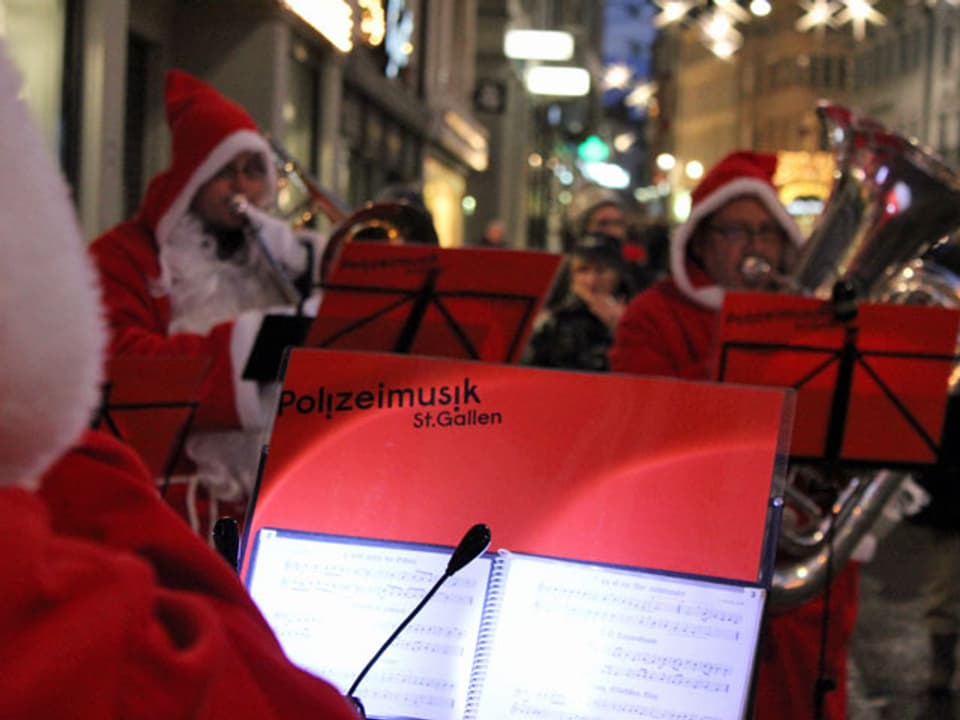 Blasmusiker als Samichläuse verkleidet. Im Vordergrund ein Notenblatt von der Polizeimusik St. Gallen