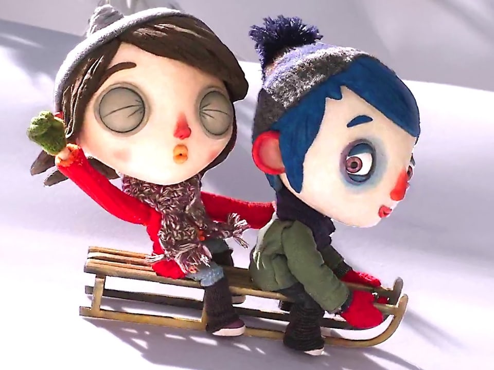 Filmheld Courgette rast mit seiner Freundin auf dem Schlitten den Schneehang hinab.