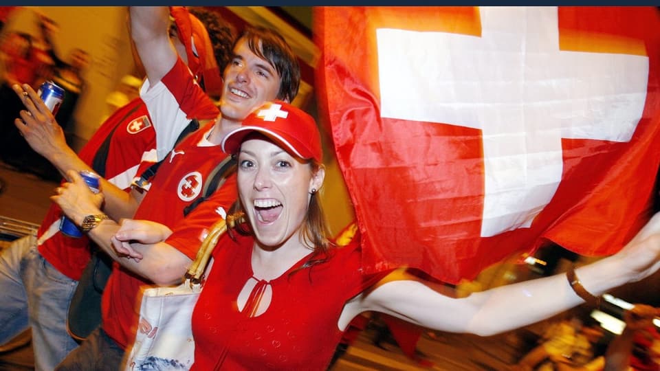 Schweizer Fans mit Fahne und roten Shirts