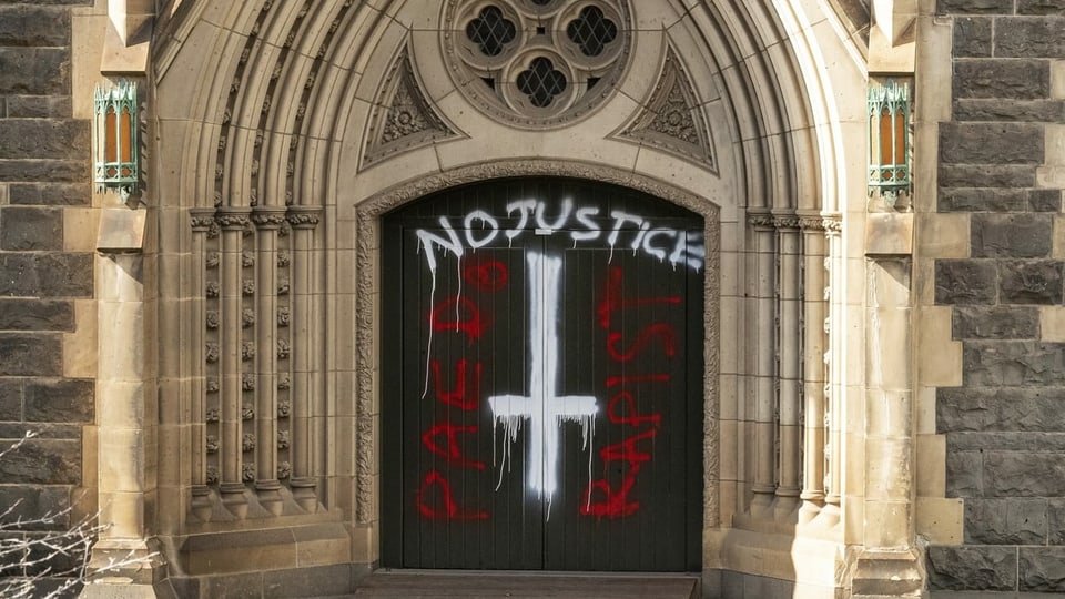 Ein Graffiti an einer Kirchentür zeigt: Der Freispruch von Kardinal Pell war nicht unumstritten.