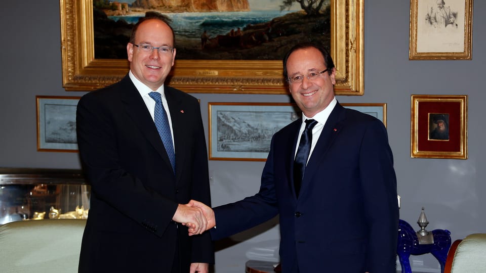 Albert und François Hollande schütteln sich die Hände.