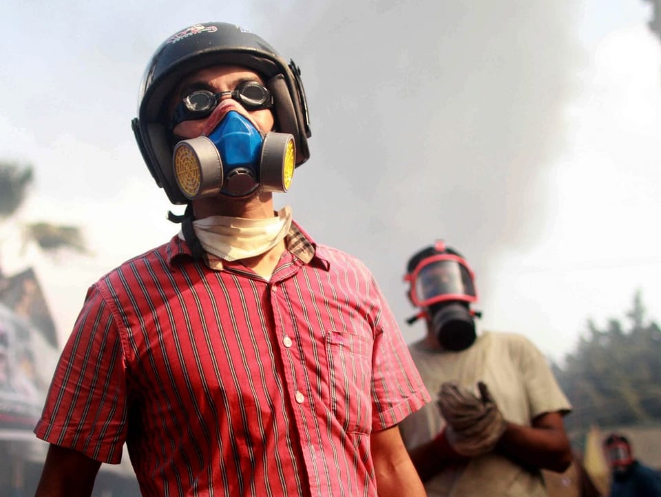 Demonstranten tragen Gasmasken