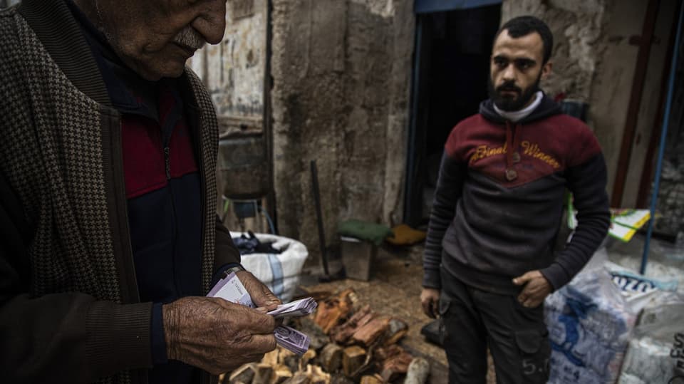 Ein Mann kauft Brennholz in Aleppo
