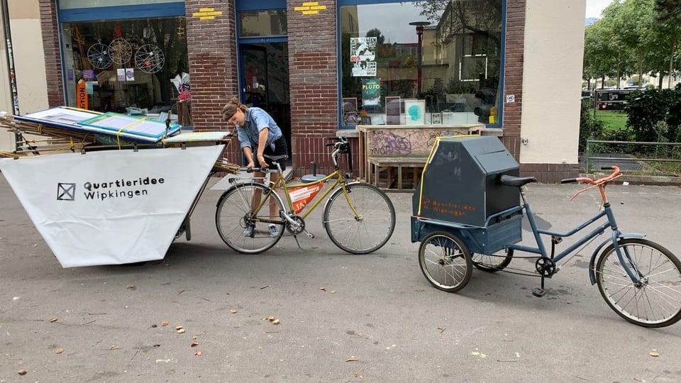 Eine Frau belädt ein Velo.