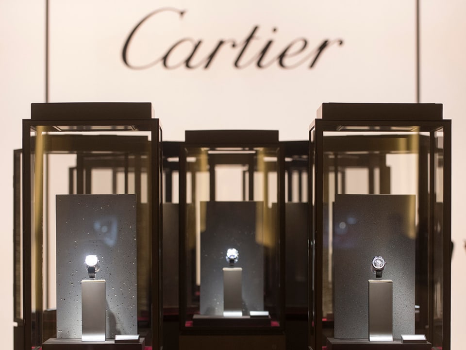 Drei Kästchen mit Uhren drin, darüber das Cartier-Zeichen.