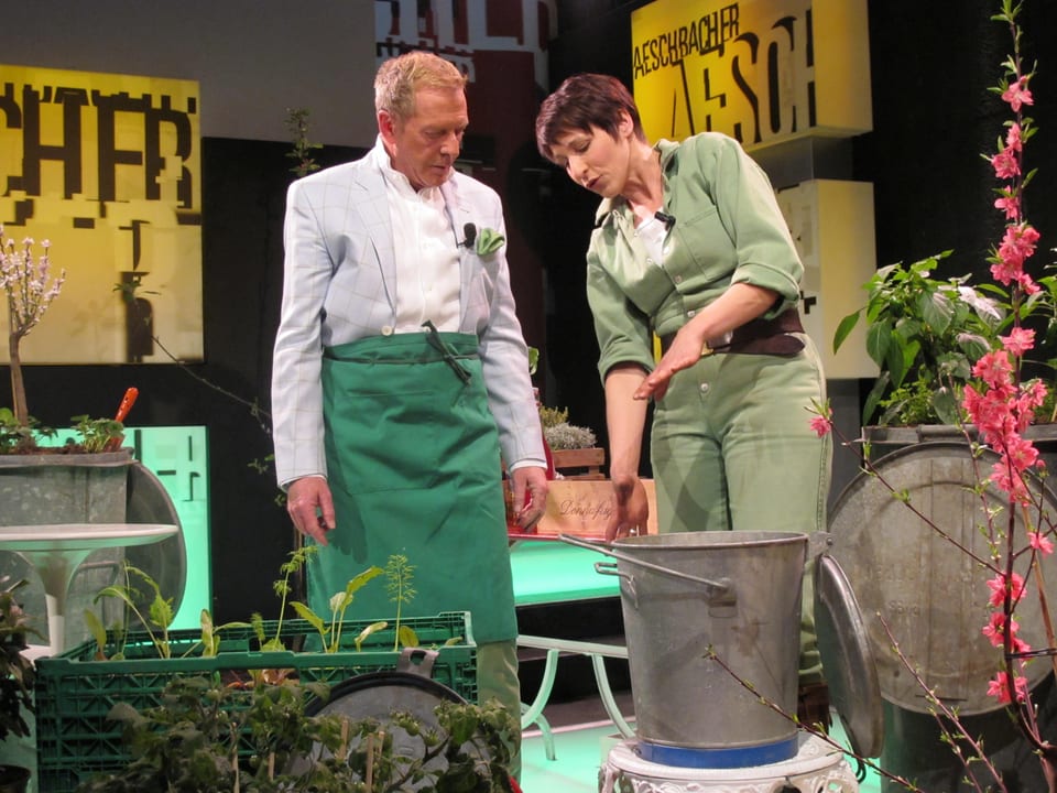 Kurt Aeschbacher mit Gartenschürze und Sabina Reber im Gespräch