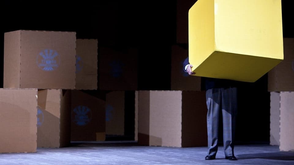 Ein Mann mit einer Box auf einer Bühne.