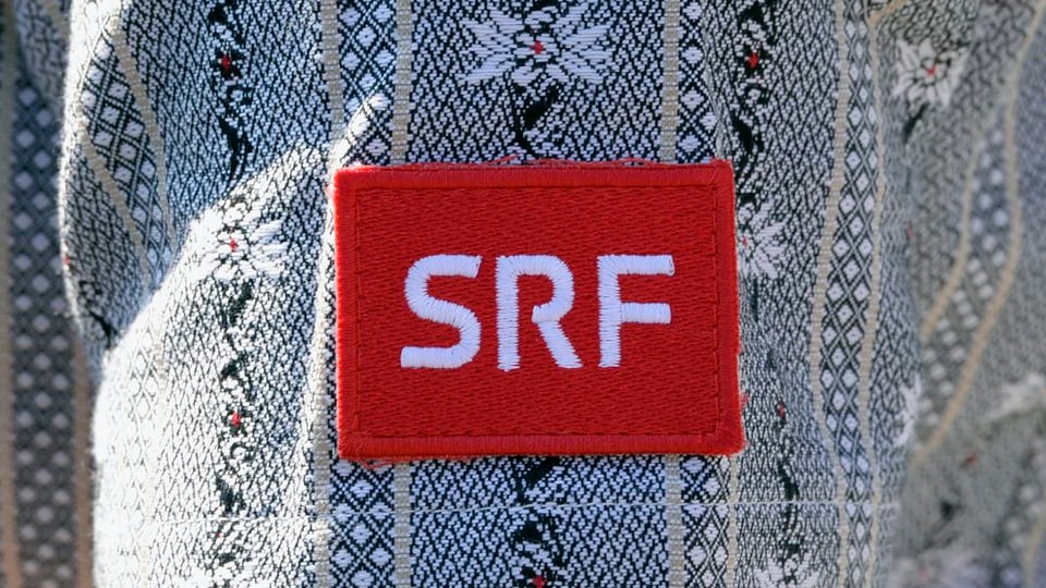 Ein SRF-Logo an einem Hemd mit Edelweiss-Verzierungen, aufgenommen am Eidgenössischen Schwingfest 2013.