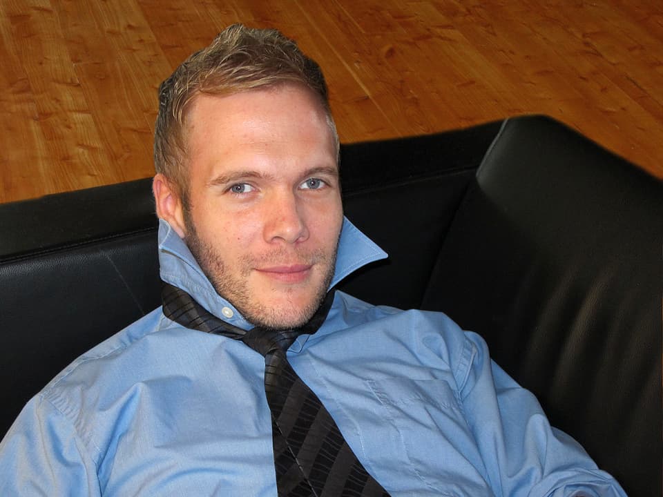 Stefan Siegenthaler liegt mit lockerer Krawatte um den Hals auf einem schwarzen Ledersofa (Bildmontage).
