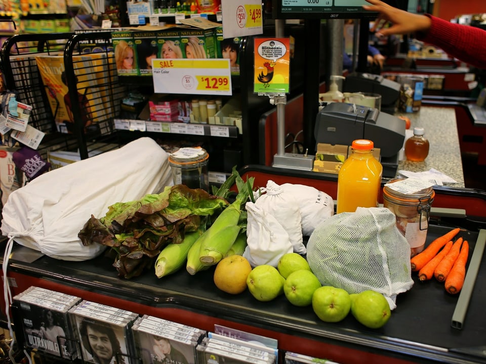Unverpackte Lebensmittel auf einem Förderband im Supermarkt.