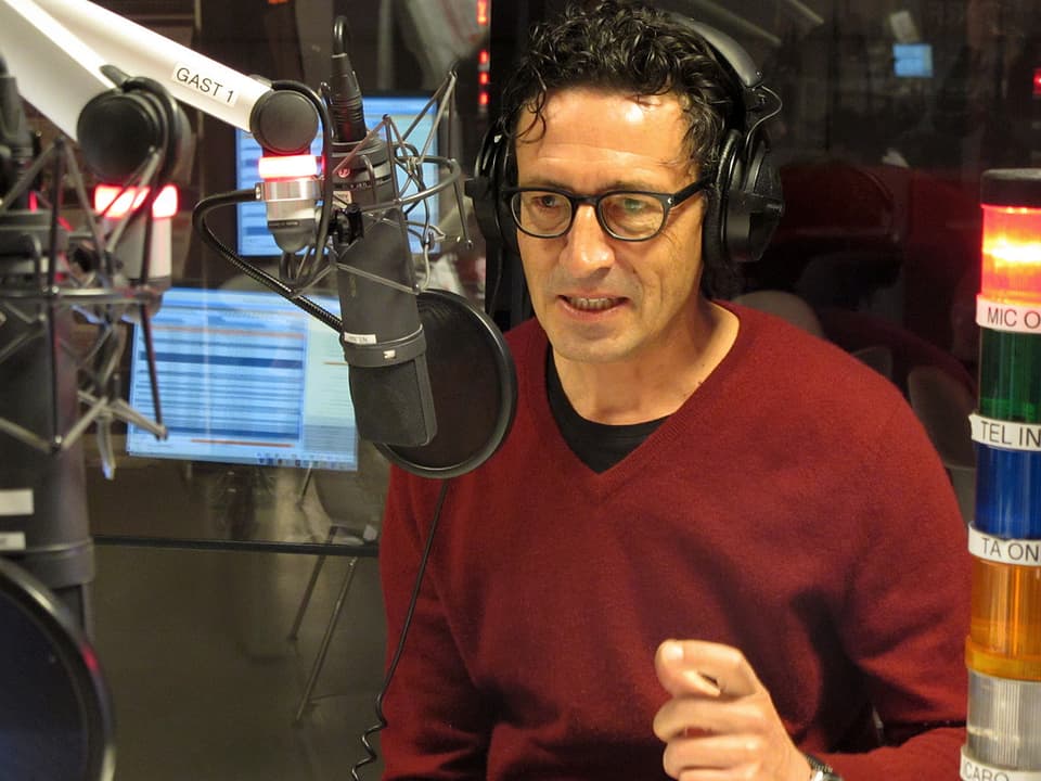 Zukunftsforscher Georges T. Roos sitzt im Radiostudio und spricht ins Mikrofon.