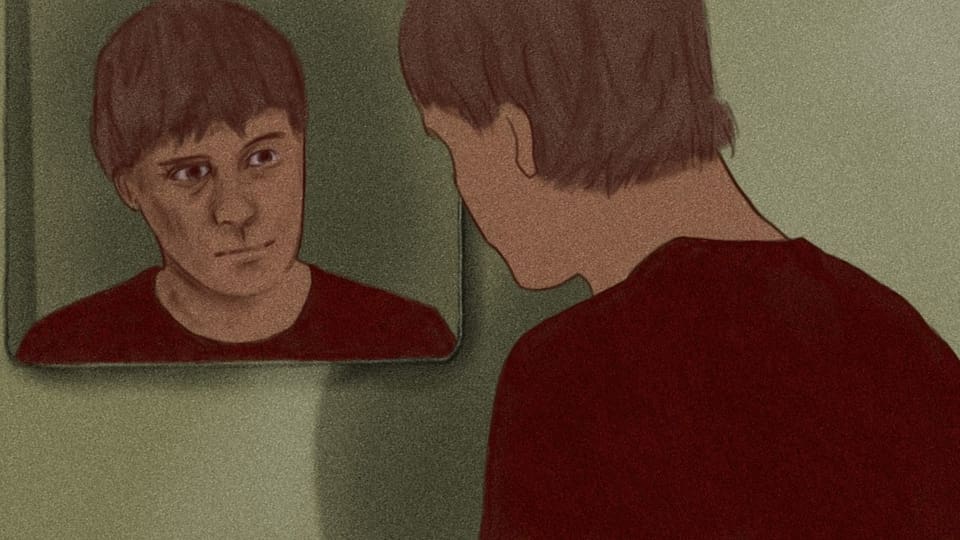 Ein junger Mann blickt in den Spiegel.