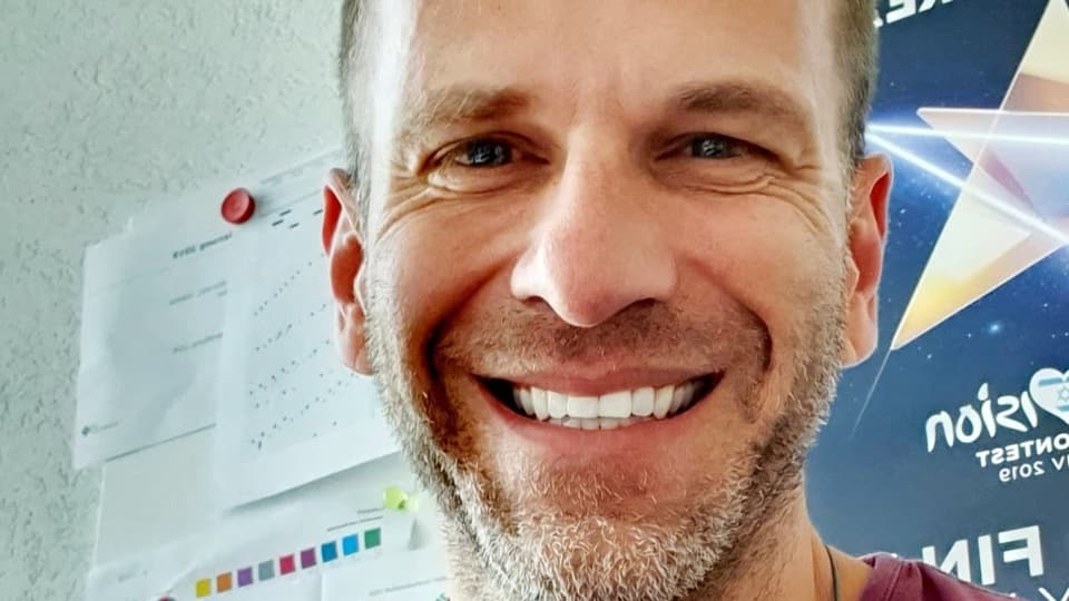 Tom Glanzmann Porträtfoto eines lachenden Mannes.