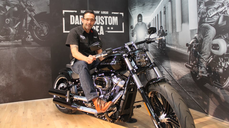 Der Chef der des Harley-Shops posiert auf einer Harley