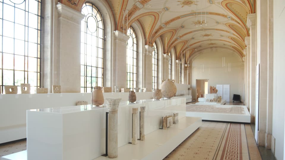 eine Museumshalle mit vielen antiken Vasen und einer schön gewölbten Decke
