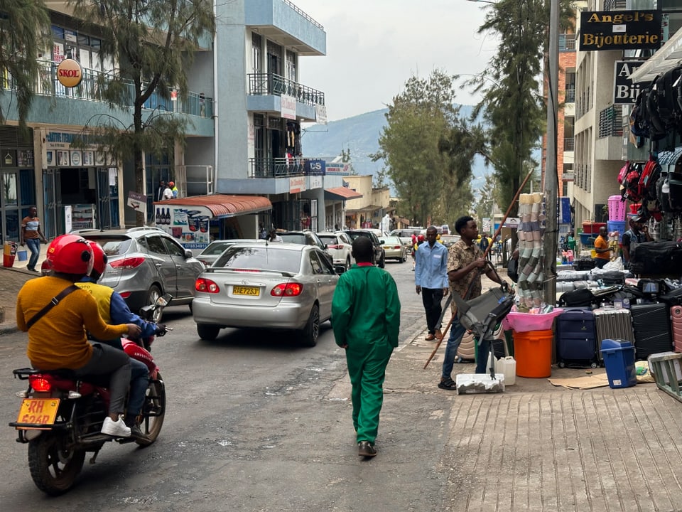 Die Strasse von Ruanda mit Menschen, Motorbikes und Autos. 