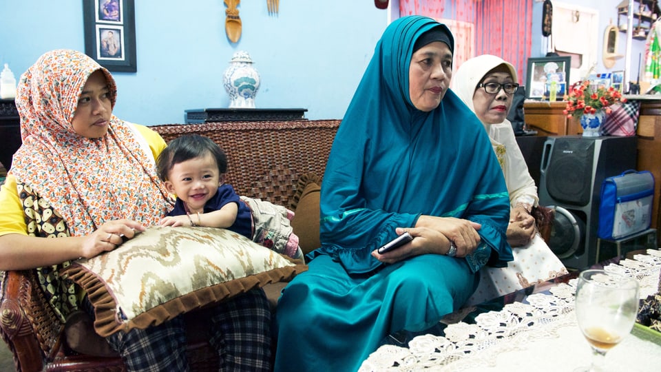 Zulbaidah sitzt mit zwei Frauen auf dem Sofa.