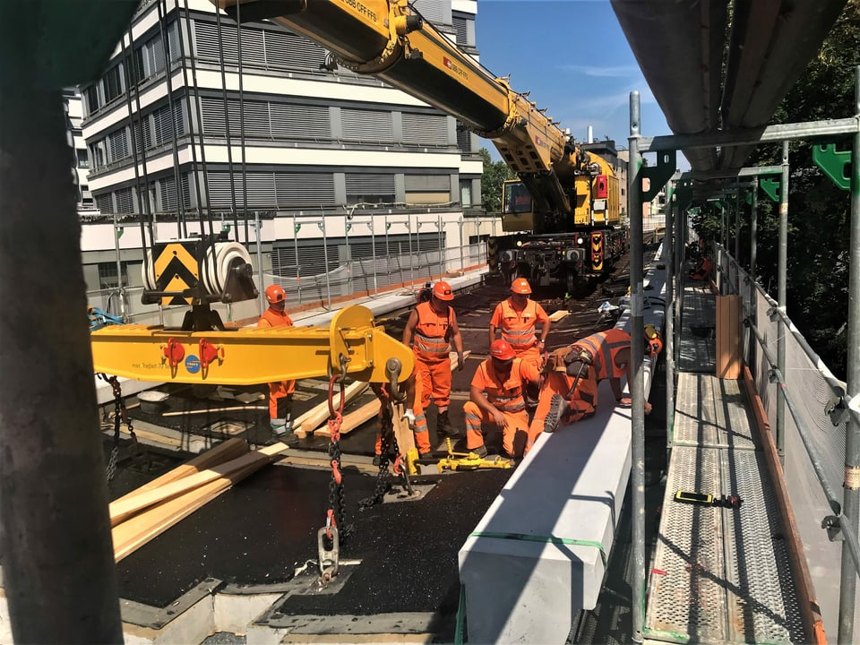 Ein Brückenbaukran der SBB liefert die Betonelemente per Schiene an.