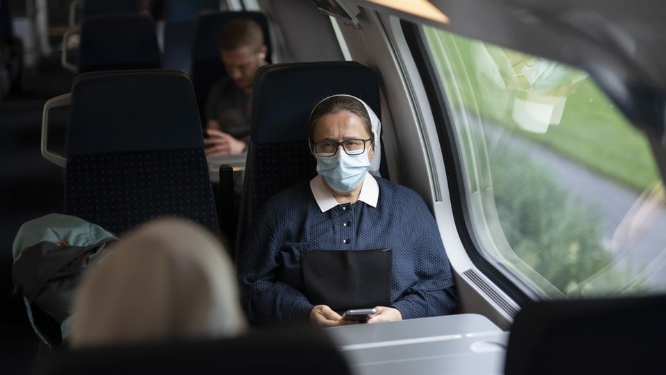 Eine Frau mit Maske im Zug
