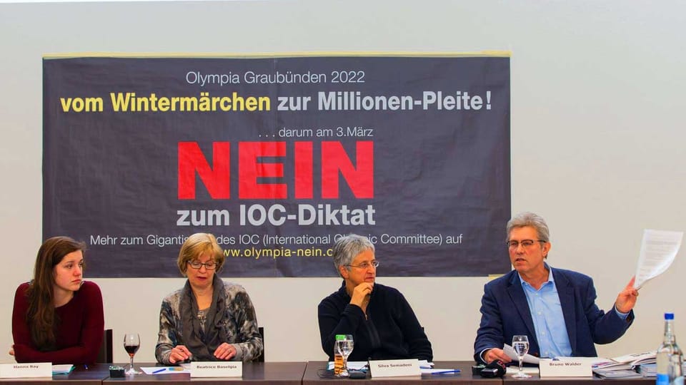 Drei Frauen und ein Mann sitzen vor einem Plakat an einer Pressekonferenz