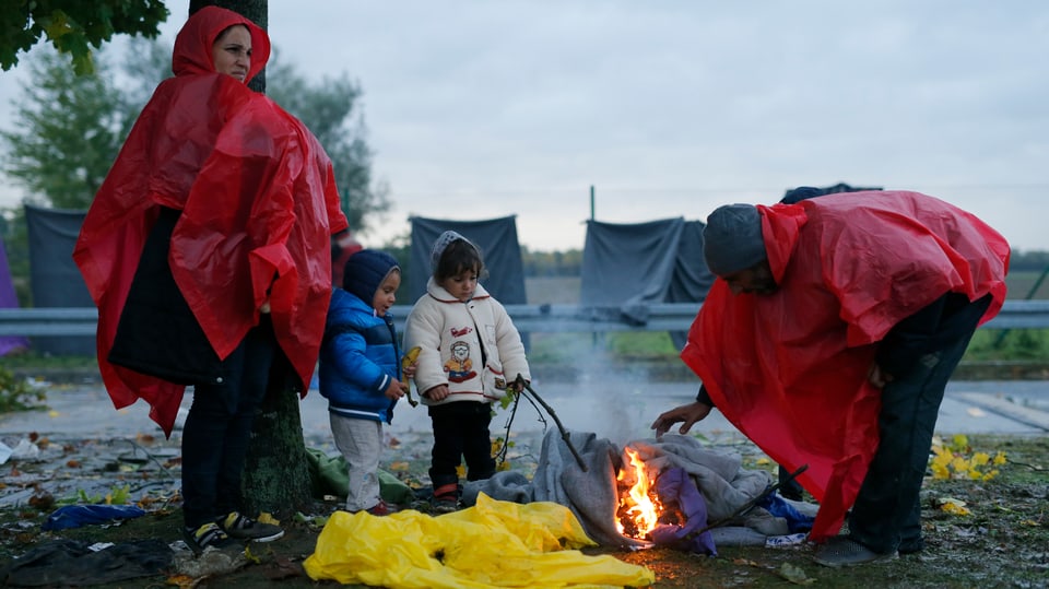 Eine Flüchtlingsfamilie wärmt sich am Feuer auf 