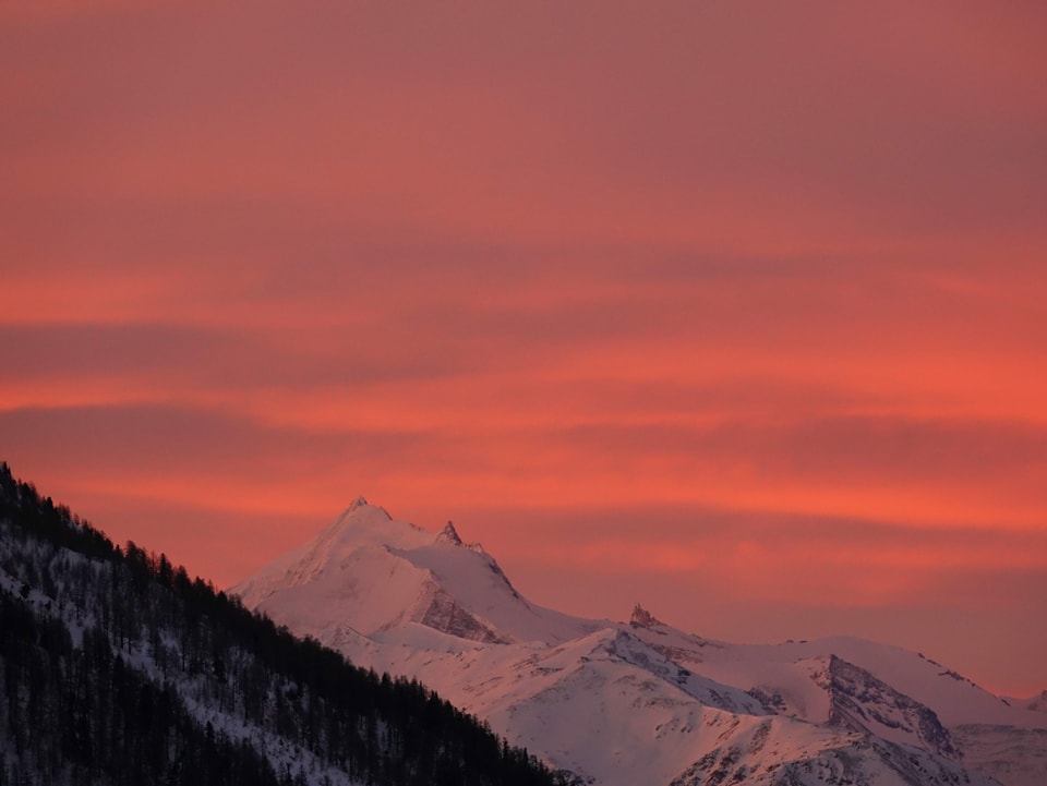 Rosa Himmel mit Wolken, unten Schneeberge