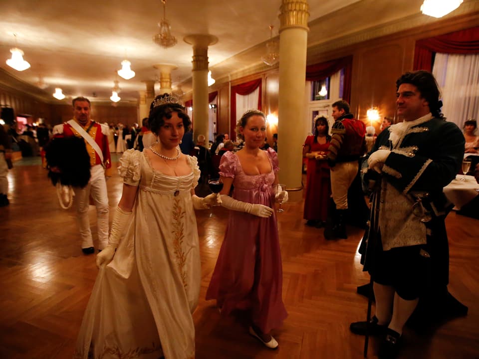 Eine dem 19. Jahrhundert nachgestellte Szene: Ein Fest, bei dem die Damen und Herren sich entsprechend gekleidet haben. 